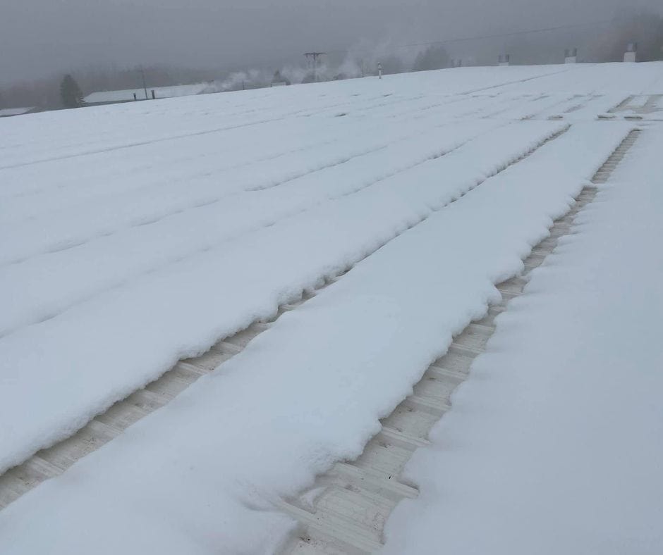 Snow unevenly melting on a roof due to heat escaping.