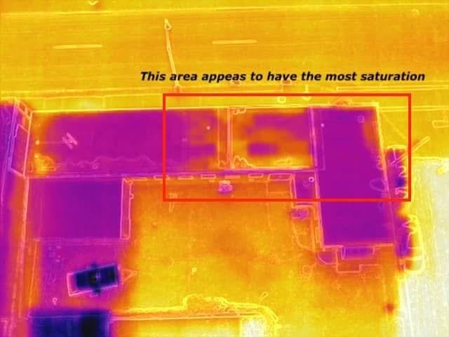 Drone inspection footage showing roof saturation (wet insulation) which indicates a leak, roof damage, or poor drainage.